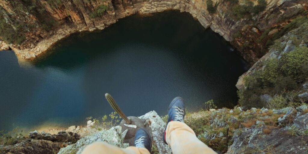 View from a cliff edge overlooking a tranquil lake, capturing adventurous spirit.